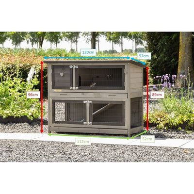 Holz-Hühnerstall mit zwei Ebenen und Drahtgitter im Garten auf Kiesboden, umlaufende Türen/Fenster; Messlinien in Zentimetern zeigen Länge 120 cm, Breite 112 cm, Höhe ca. 96 cm links und 89 cm rechts, Dachüberhang 57 cm vorn, 52 cm hinten.