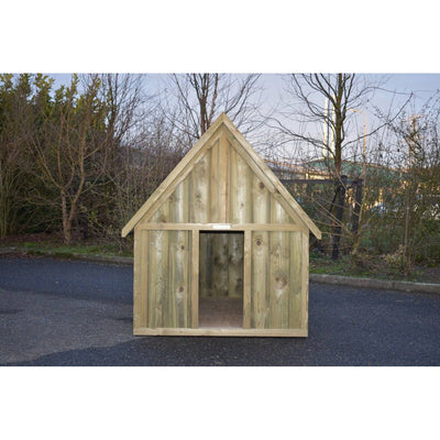 Holzspielhaus im Garten, kleines unbehandeltes Holzhäuschen mit Giebeldach und offener Eingangstür, steht auf Asphaltfläche vor Bäumen.