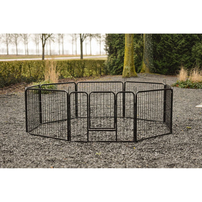 Schwarzes, modular aufgebautes Hundegitter aus Metall in kreisförmiger Anlage mit zentraler Tür, auf Kiesboden im Garten.